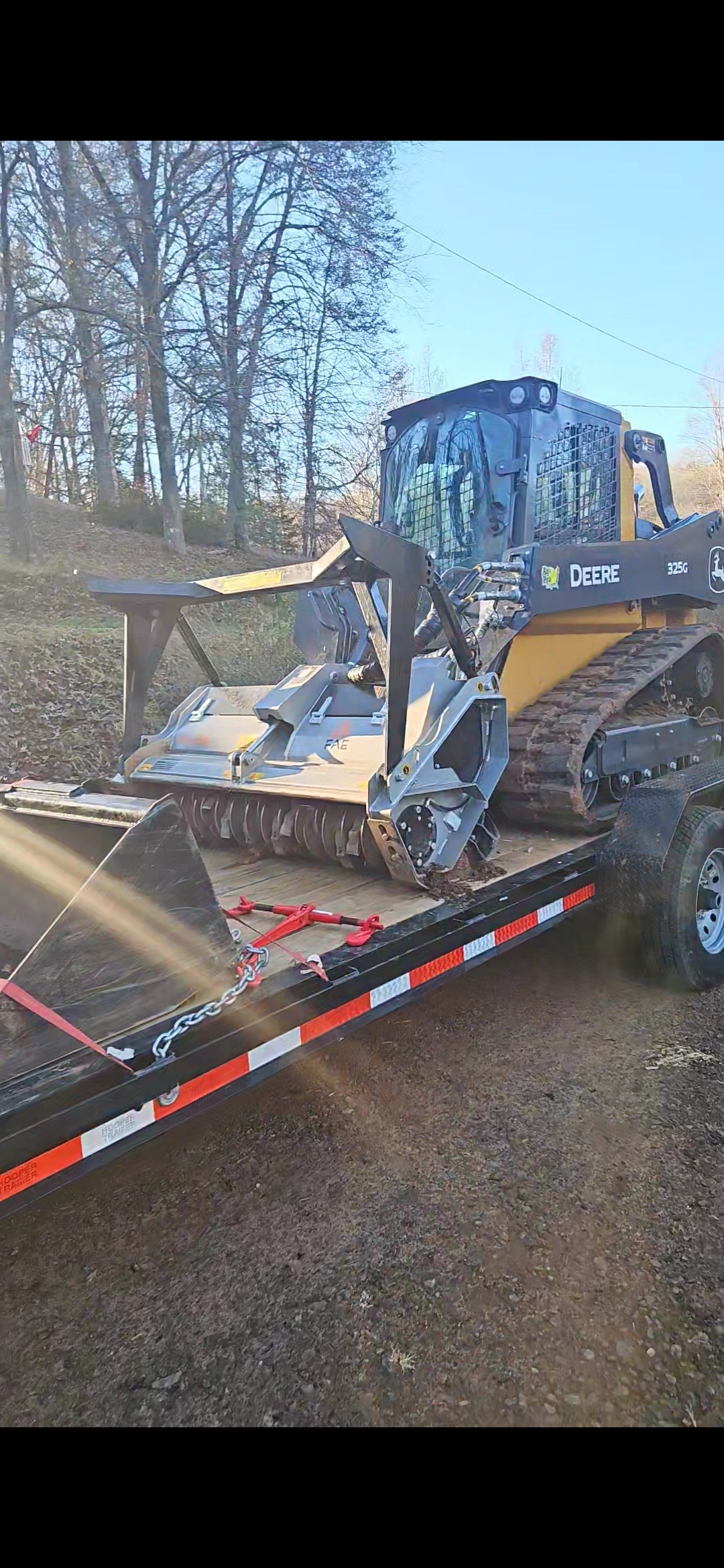 John Deere 325G skid steer with FAE DML forestry mulcher head loaded on trailer ready for land clearing job in Piedmont SC